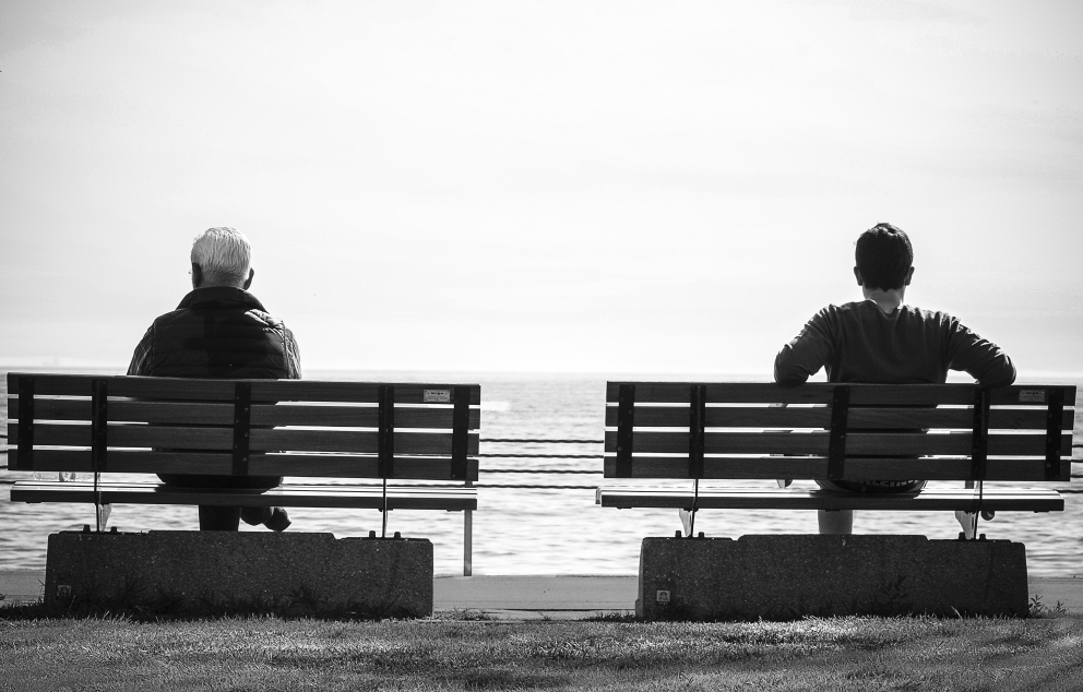 אדם מבוגר ואדם צעיר יושבים על ספסל מול הים   מקור: נגטיב ספייס